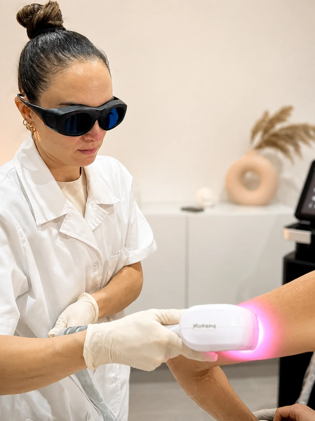 Mitarbeiterin von dermame bei der Haarentfernung mit dem eigenen Behandlungsgerät